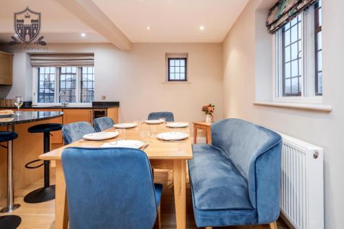 a dining room with a wooden table and blue chairs at Castle Properties:Eton-The College in Windsor