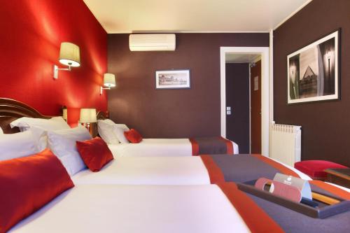 a hotel room with two beds and a red wall at Hotel Trianon Rive Gauche in Paris
