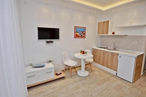 cocina blanca con mesa, fregadero y encimera en Gospostina Apartment, en Budva