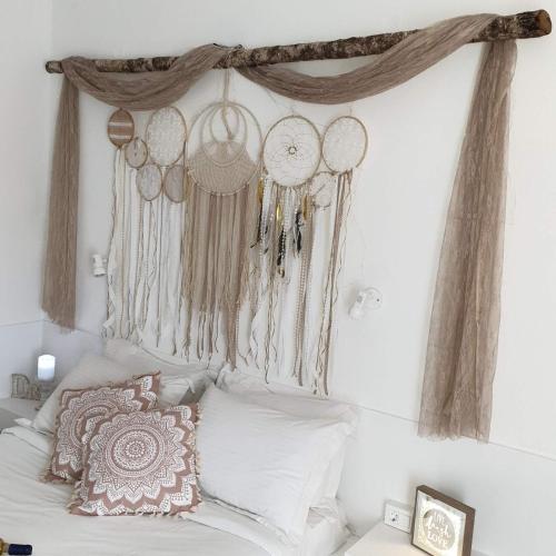 a bedroom with a bed with decorations on the wall at Sagma Central Rooms in Perissa