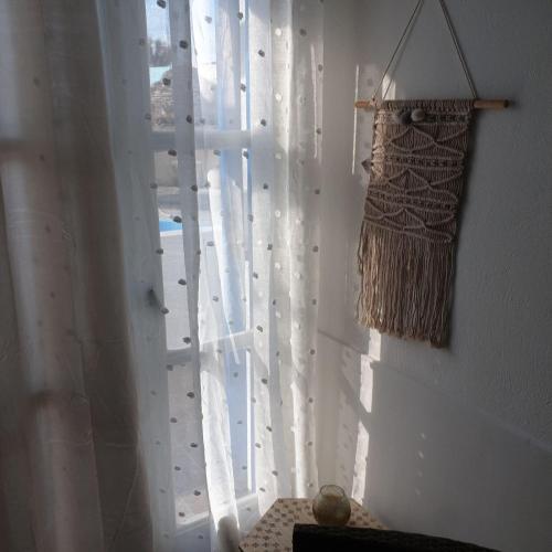a window with a curtain and a basket on a wall at Sagma Central Rooms in Perissa