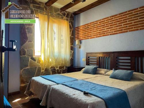 a bedroom with two beds and a sign on the wall at Casa el Mirador de Gredos Norte in Hoyocasero