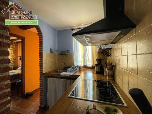 a kitchen with a sink and a stove top oven at Casa el Mirador de Gredos Norte in Hoyocasero
