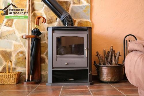 a fireplace with a hair dryer on top of it at Casa el Mirador de Gredos Norte in Hoyocasero