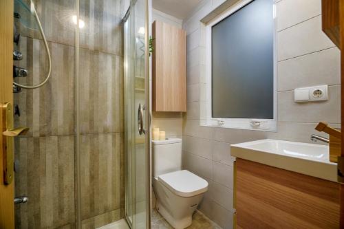 a bathroom with a toilet and a sink and a shower at San Amaro Beach 3 by TheBlueWaveApartments com in A Coruña