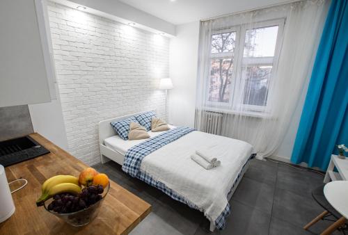 1 dormitorio con 1 cama y un plato de fruta en una mesa en Apartament Estakada 2, en Częstochowa