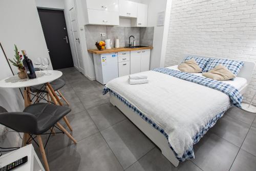 a small bedroom with a bed and a kitchen at Apartament Estakada 2 in Częstochowa