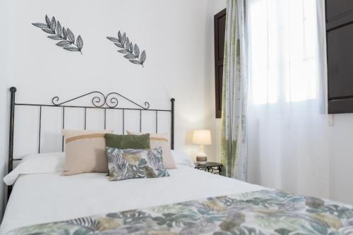 a bedroom with a bed with a white bedspread at La Gitanilla Alojamiento & Encanto Jerez in Jerez de la Frontera