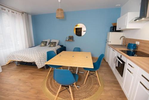 une cuisine avec une table et des chaises dans une pièce dans l'établissement Les Songes de la Tour, à Vermenton