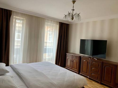 - une chambre avec un lit et une télévision à écran plat dans l'établissement Апартаменти в новобудові, à Lviv