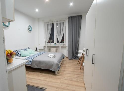 a small bedroom with a bed and a kitchen at Apartament Estakada in Częstochowa