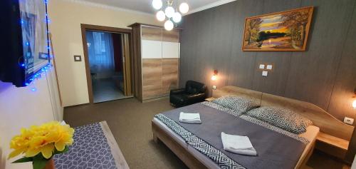 sypialnia z łóżkiem i wazonem kwiatów w obiekcie Szlavi Apartman w mieście Baja