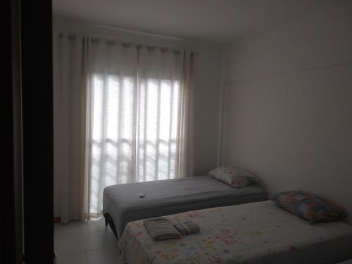 a bedroom with two beds in front of a window at IMBASSAI... UM PARAISO ESPERANDO POR VOCE in Mata de Sao Joao