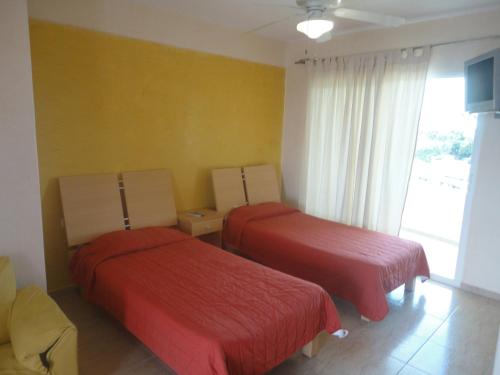 a hotel room with two beds and a window at Suites Moon River in Cancún