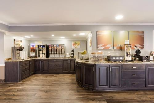 a large kitchen with dark wood cabinets and counters at Red Roof Inn & Suites Athens, AL in Athens