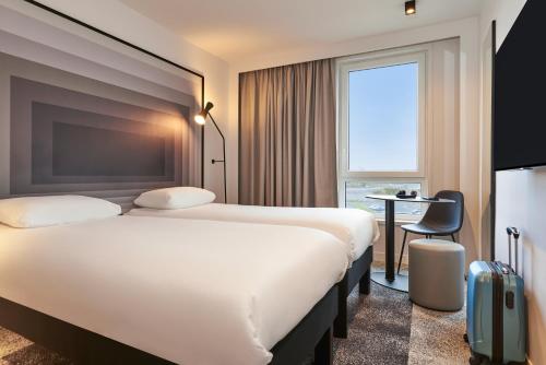 ein Hotelzimmer mit 2 Betten und einem Schreibtisch in der Unterkunft ibis Bethune Centre Gare in Béthune