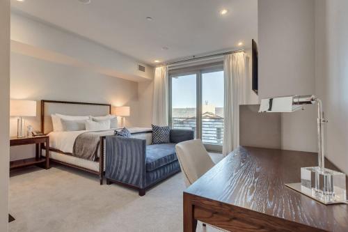 a bedroom with a bed and a couch and a window at Stein Eriksen Residences in Park City