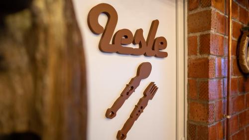 a sign for a restaurant with cutlery on a wall at ȘURA LU' PĂTRU in Vulcan