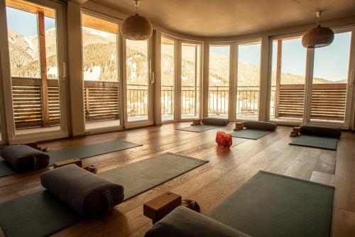 a room with a bunch of yoga mats in a room with windows at Boutique Hotel Bellevue Lermoos in Lermoos