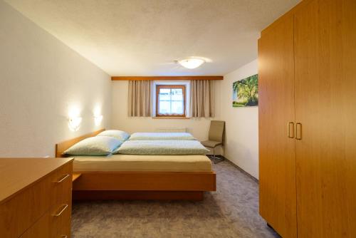 ein kleines Schlafzimmer mit einem Bett und einem Fenster in der Unterkunft Haus St. Bernard in Pettneu am Arlberg
