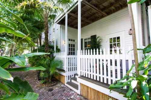 a white house with a fence and palm trees at Old Town Manor in Key West