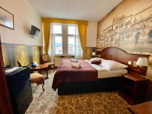 プラハにあるホテル リリオヴァ プラハ オールド タウンの大きなベッドと大きな絵画が壁に描かれたベッドルーム1室