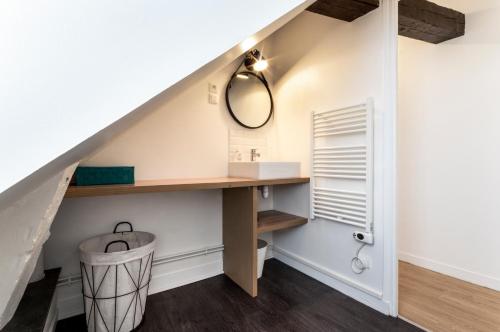 - une salle de bains sous les escaliers avec une coiffeuse et un miroir dans l'établissement Le Doux Refuge - Spacieux - 6 pers, au Havre