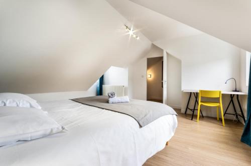 une chambre blanche avec un lit et un bureau dans l'établissement Le Doux Refuge - Spacieux - 6 pers, au Havre