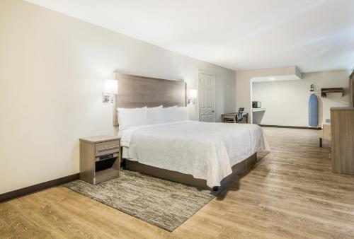 a bedroom with a large bed with a white bedspread at Days Inn by Wyndham Chula Vista-San Diego in Chula Vista