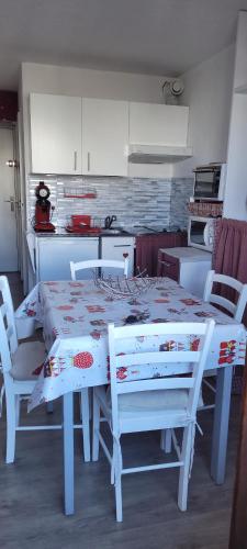 tavolo e sedie bianchi in cucina con tavolo di Appartement sur le Parc des Ecrins a Puy-Saint-Vincent