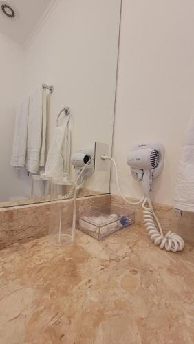a dirty bathroom with a hair dryer and a mirror at Apartamento 50m2 Hospital Einstein Morumbi in Sao Paulo