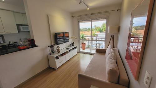a living room with a couch and a large window at Apartamento 50m2 Hospital Einstein Morumbi in Sao Paulo