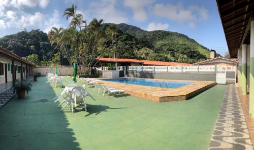 
a dog standing in front of a swimming pool at Hotel Pousada Nosso Cantinho in Ubatuba
