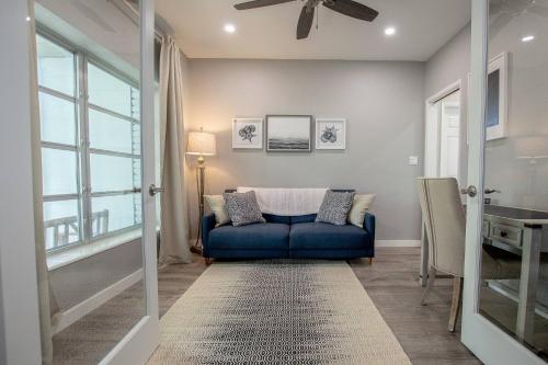 a living room with a blue couch and a window at Sunrise on Lake Idylwild in Winter Haven