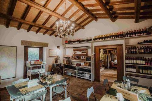BagnaiaにあるAgriturismo I Giardini Di Araratのテーブルと椅子、シャンデリアが備わる広い客室です。