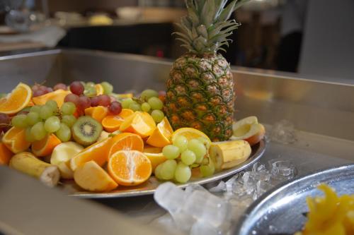 a plate of fruit on a counter with a pineapple at Wellness Hotel Astra in Špindlerův Mlýn
