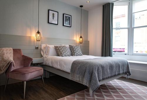 a bedroom with a bed and a chair and a window at Nitehouse in Reading