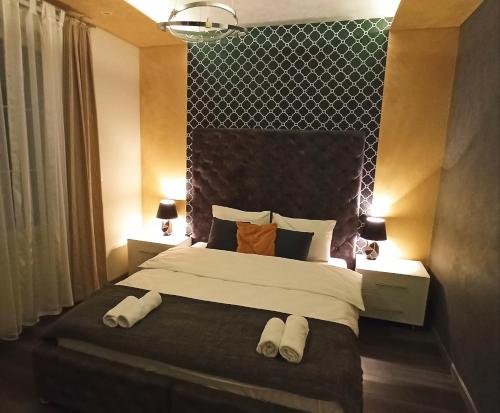 1 dormitorio con 1 cama con 2 toallas en Apartmani President III, en Banja Luka