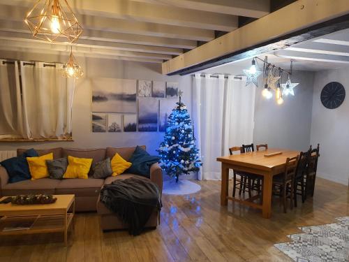 una sala de estar con un árbol de Navidad y un sofá en Au P'ti Parc de Madon, en Candé-sur-Beuvron