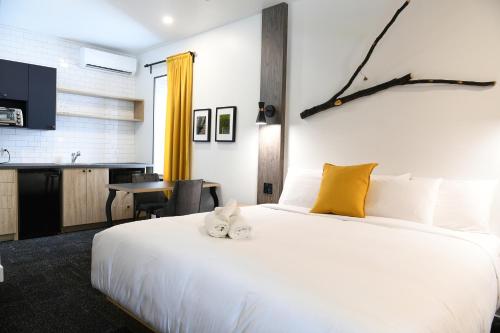 a bedroom with a large white bed and a desk at Hotel Le Bloc in Quebec City