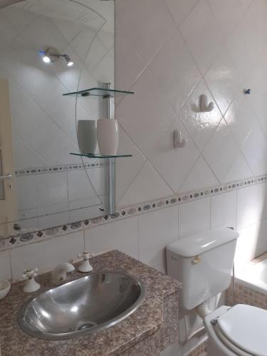 ein Badezimmer mit einem Waschbecken, einem WC und einem Spiegel in der Unterkunft PARQUE LELOIR, ITUZAINGO in Villa Leloir