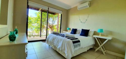 - une chambre avec un lit et une grande fenêtre dans l'établissement Sovereign Sands 2, à KwaDukuza