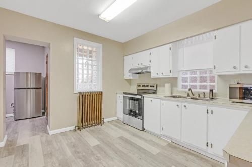 an empty kitchen with white cabinets and appliances at Spacious 3BR Home near Downtown, Oakland & East Liberty! Max 15 nights in Pittsburgh