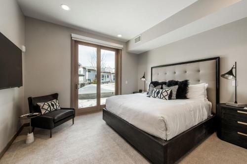 a bedroom with a large bed and a chair at Stein Eriksen Residences in Park City