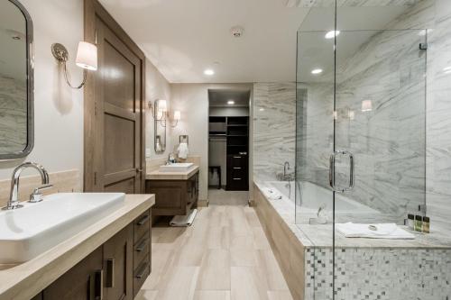 a bathroom with a tub and a sink and a shower at Stein Eriksen Residences in Park City