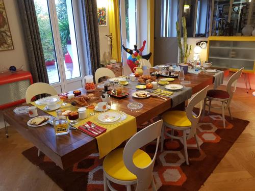 een houten tafel met eten erop in een eetkamer bij Le Jardin des Toiles in Triel-sur-Seine