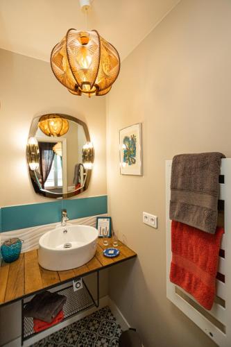 une salle de bain avec un lavabo et un miroir dans l'établissement Le Jardin des Toiles, à Triel-sur-Seine