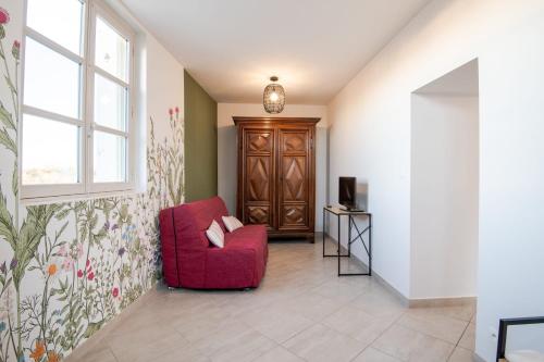 a living room with a red chair and a window at Grenier à sel quai d'Amboise# - PMR in Amboise