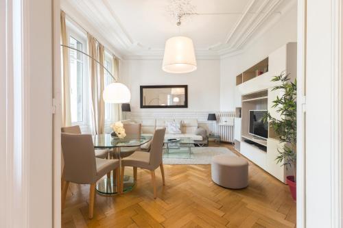 Appartement Luxueux Centre Ville في كولمار: غرفة معيشة مع طاولة وكراسي زجاجية