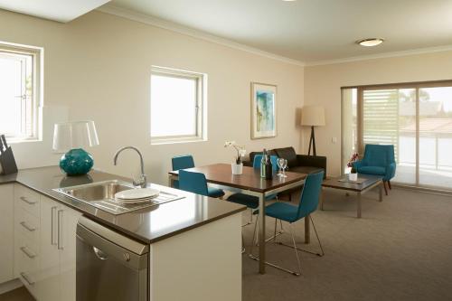una cucina e un soggiorno con tavolo e sedie di Baileys Serviced Apartments a Perth